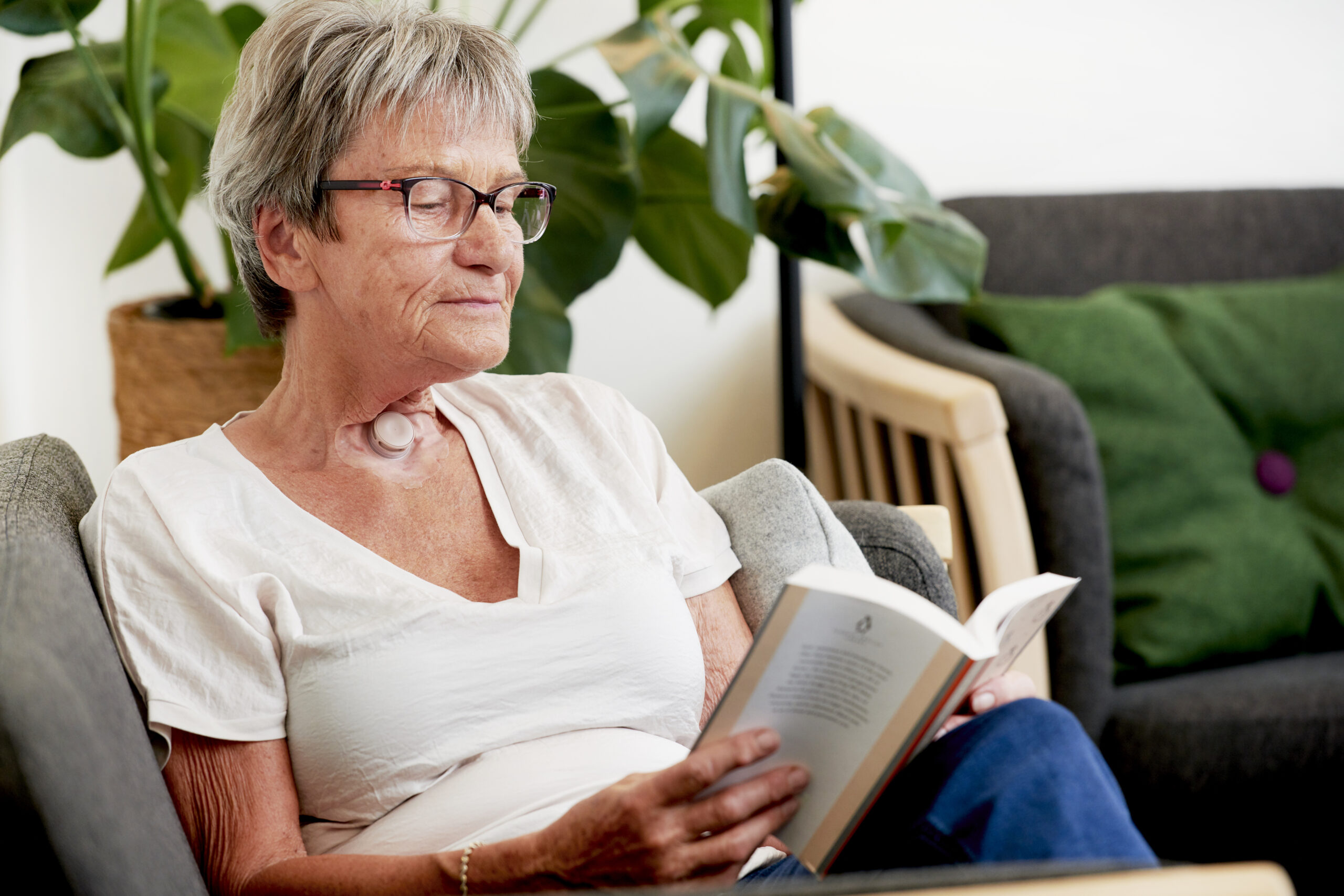 woman reading sitting on sofa using provox life hme