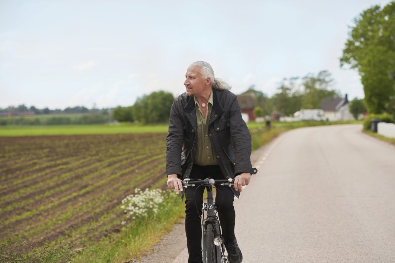 man with a neck stoma biking outdoors